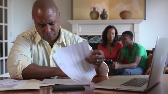 一位父亲与家人一起处理家庭财务问题