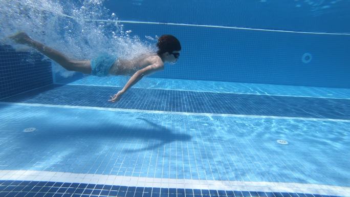 快乐的男孩跳进了游泳池