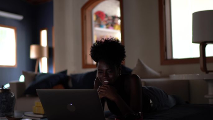 年轻女性在家里用笔记本电脑看电影