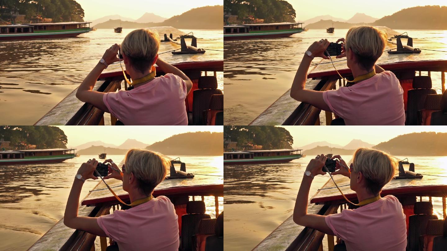 湄公河游船上用相机拍摄日落的女人