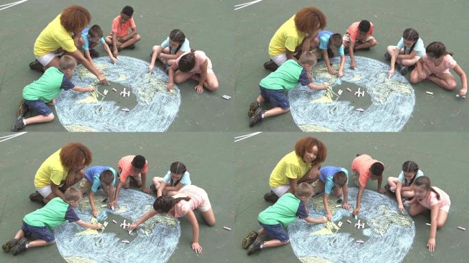 夏令营学生与老师在地上画地球