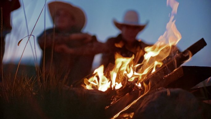 篝火旁的男人西部牛仔火焰火光户外野营