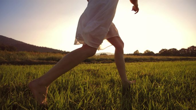 在草地上赤脚奔跑草坪草丛女孩小孩开心追梦