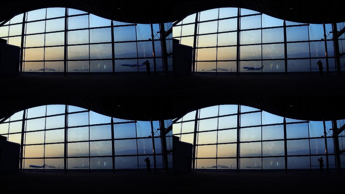 候机楼大门内的飞机降落和日落景观