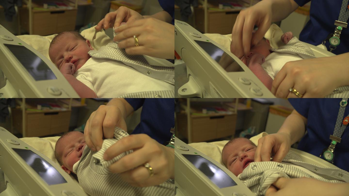 医院里的新生婴儿被助产士穿上衣服