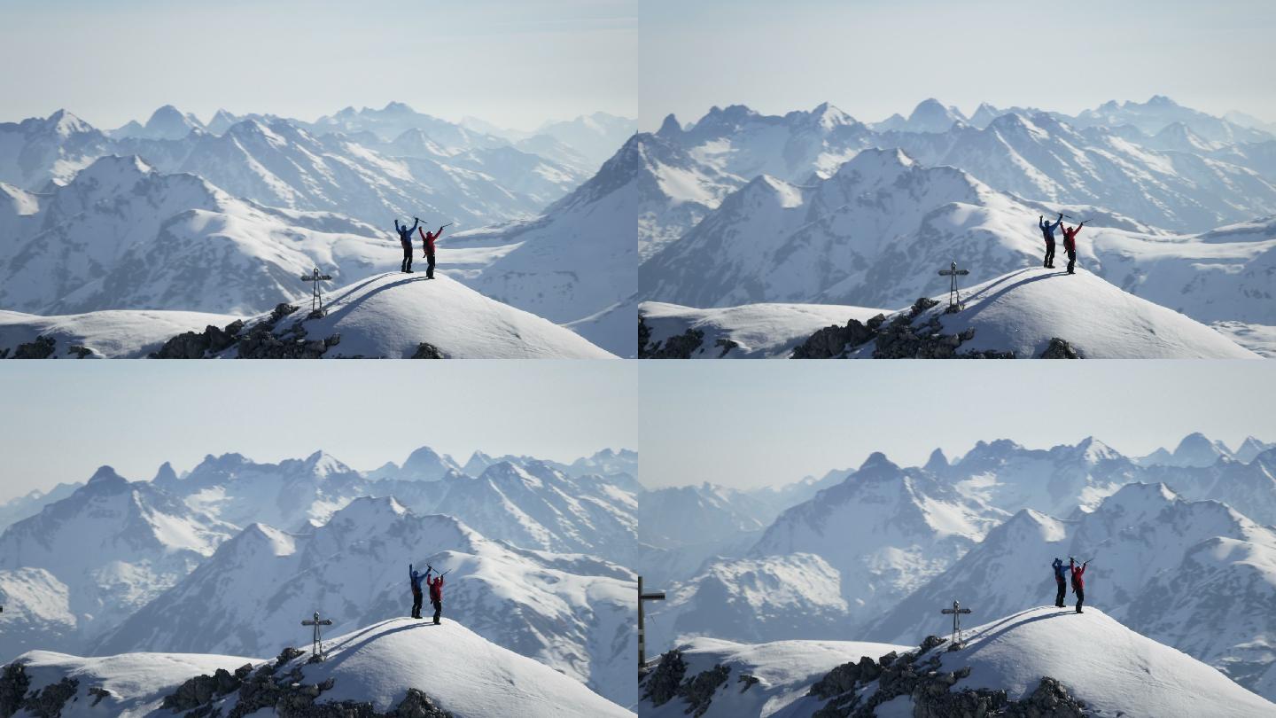 登山者在白雪覆盖的山峰上欢欣鼓舞