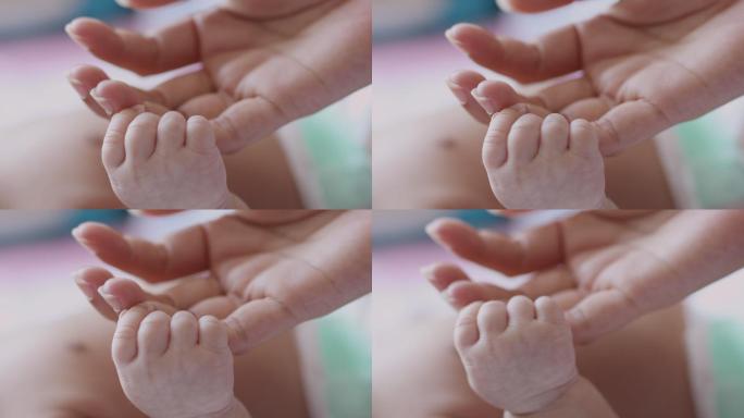 婴儿抓住母亲的手指