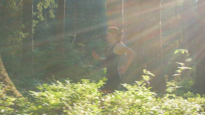 在树林奔跑的女运动员