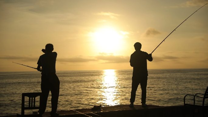 【原创】实拍清晨日出时海边钓鱼的人剪影