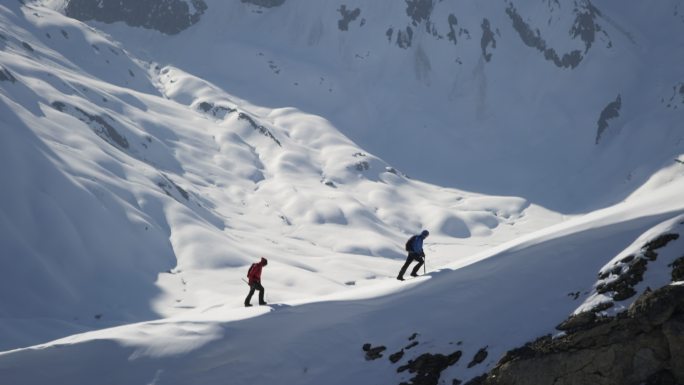 登山者在白雪覆盖的山上行走