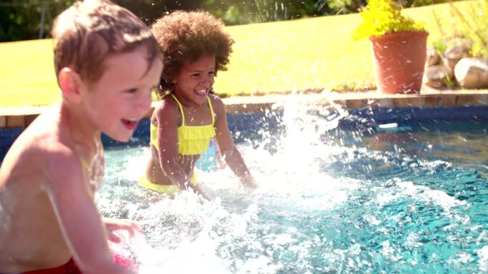 小女孩和朋友在游泳池里嬉戏