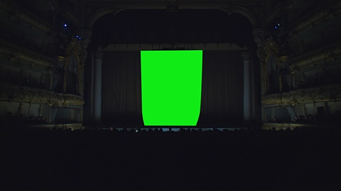 在剧院的舞台上，幕布在绿色的背景下拉开
