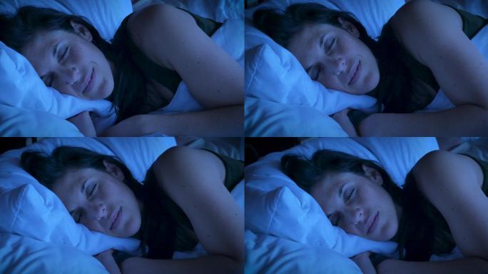 一个女人在晚上睡觉时微笑的特写镜头