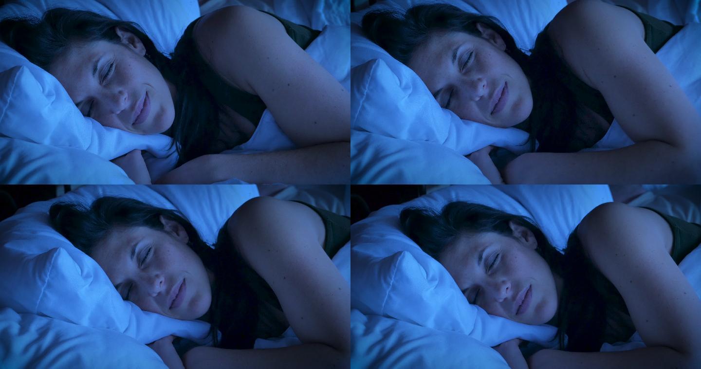 一个女人在晚上睡觉时微笑的特写镜头