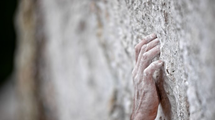 一个男性攀岩者的手在抓紧墙壁