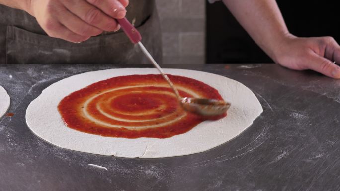 做披萨，涂番茄酱桌子家庭生活家庭厨房