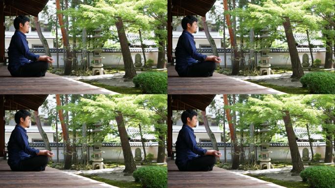 坐在佛寺花园里冥想的人