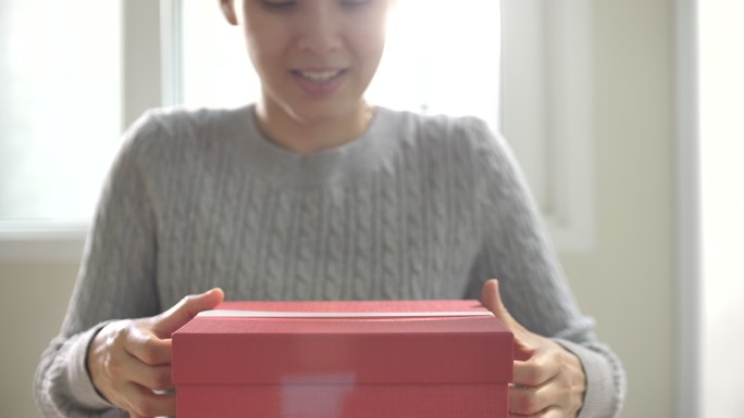 女子打开红色礼盒开盲盒拆开蝴蝶结期待激动