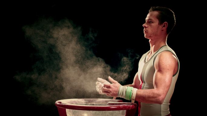 体操运动员用粉笔在碗边画他被包裹的手