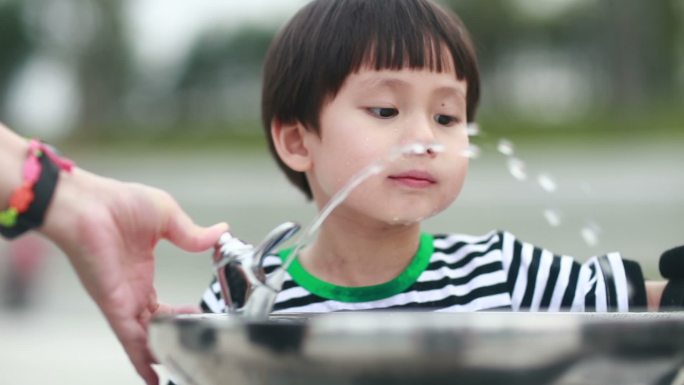 喝自来水的小男孩小朋友喝水公园