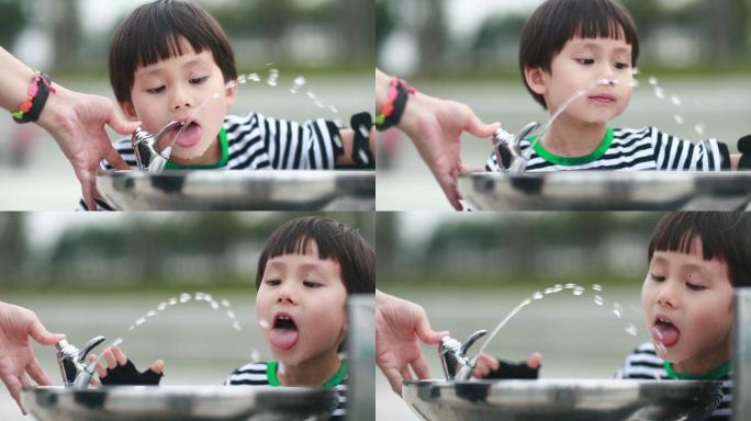 喝自来水的小男孩小朋友喝水公园