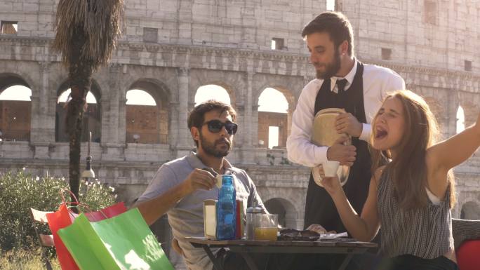 罗马斗兽场前的餐厅里有一对情侣在喝咖啡