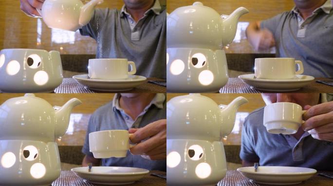 端着茶壶往杯子里倒热茶