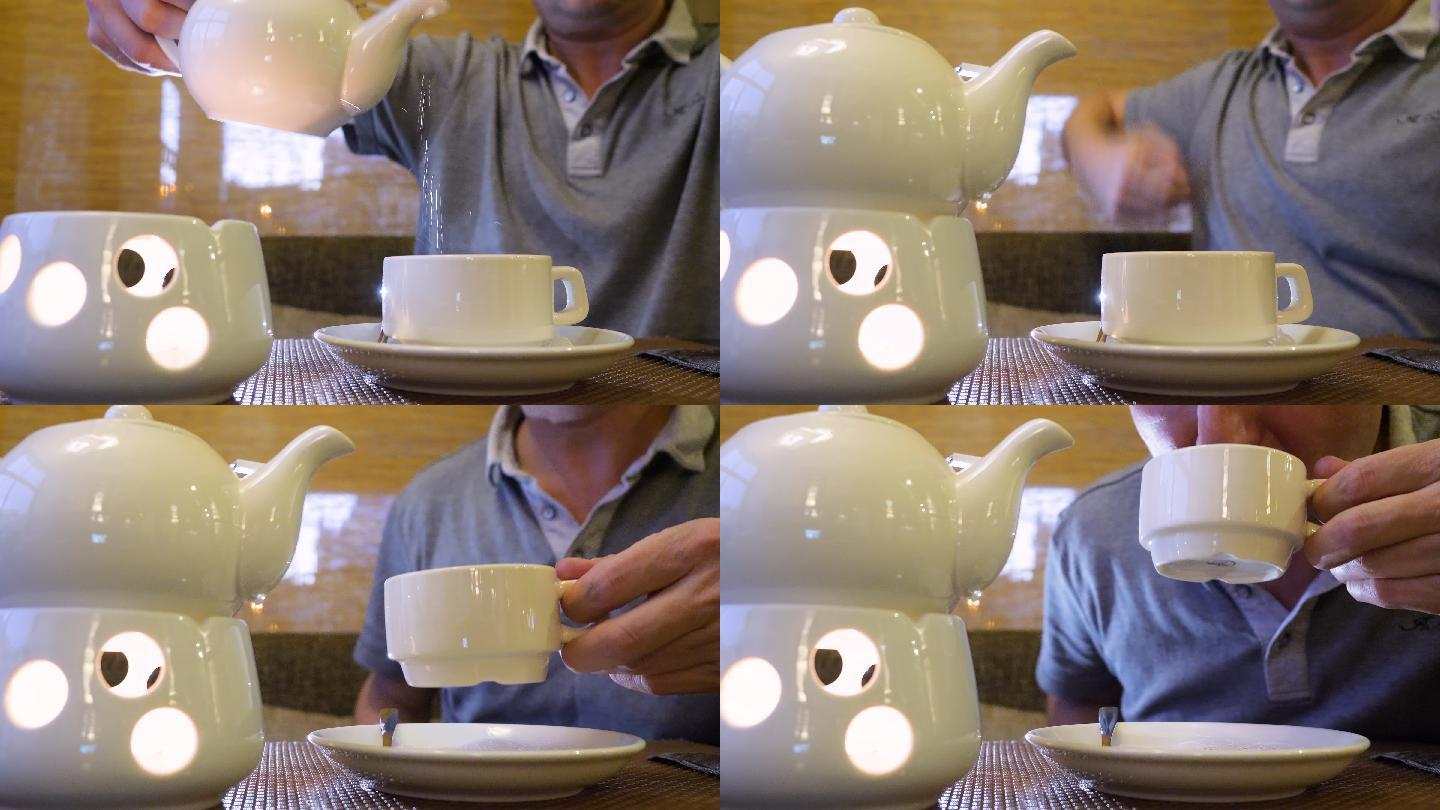 端着茶壶往杯子里倒热茶