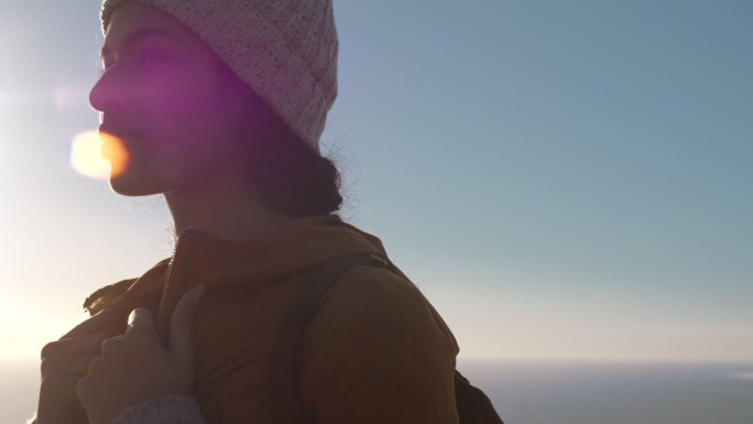 穿着暖和衣服的女人在山上欣赏风景