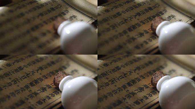 泛黄中医古书和白色陶瓷小药瓶