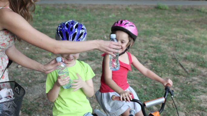 妈妈给骑自行车的孩子们喝水