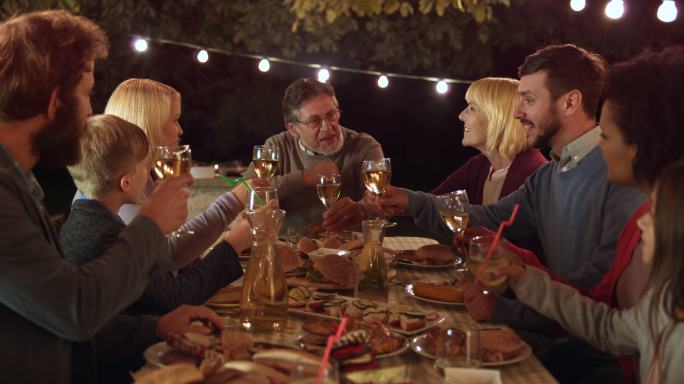 一家人晚上在野餐聚餐庆祝干杯