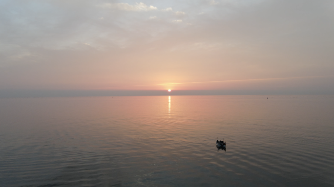无人机航拍海面夕阳与渔船