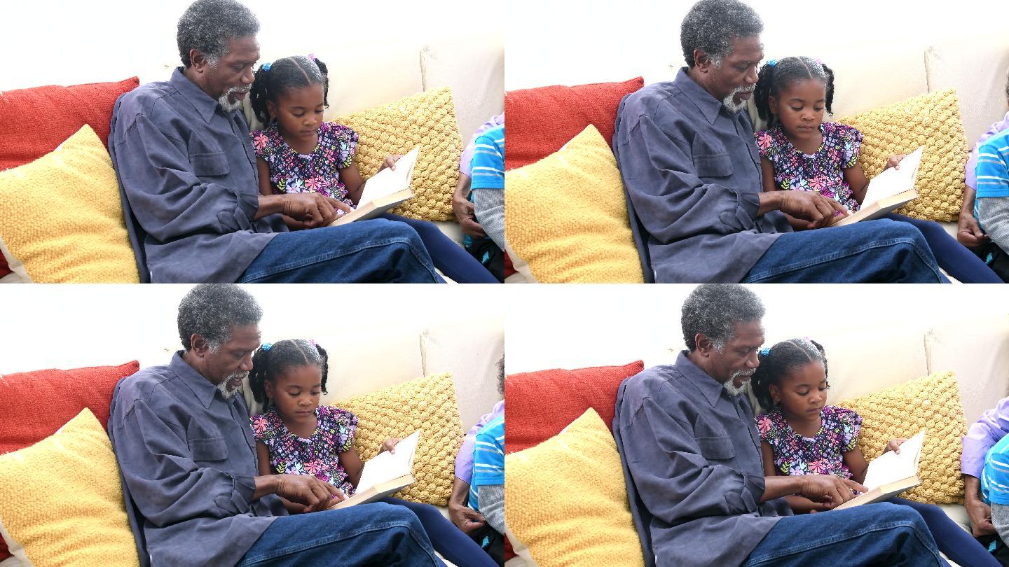 爷爷给沙发上的小女孩读书