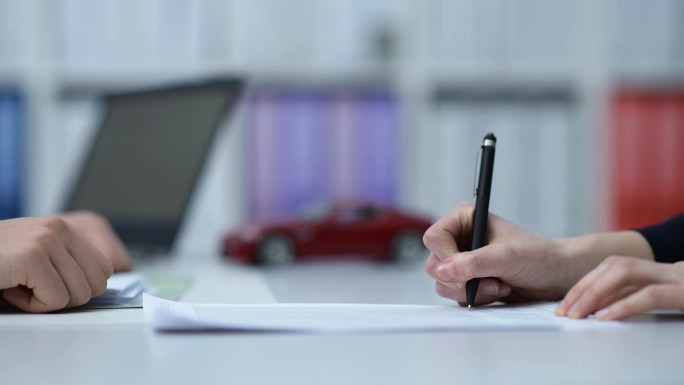 汽车经销商或保险公司向客户展示合同