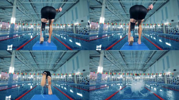 带假肢的专业游泳运动员跃入游泳池