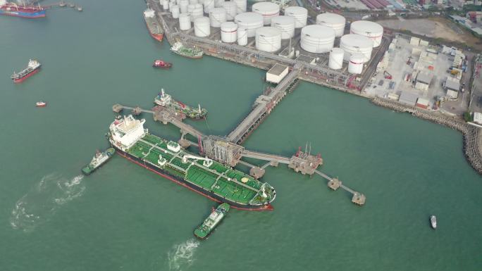 拖船将油轮推至装油码头装卸油罐内的油