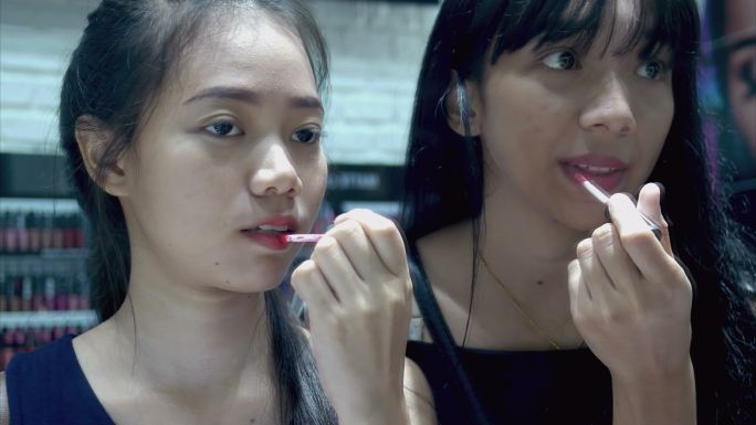 两名年轻女性在商店测试口红