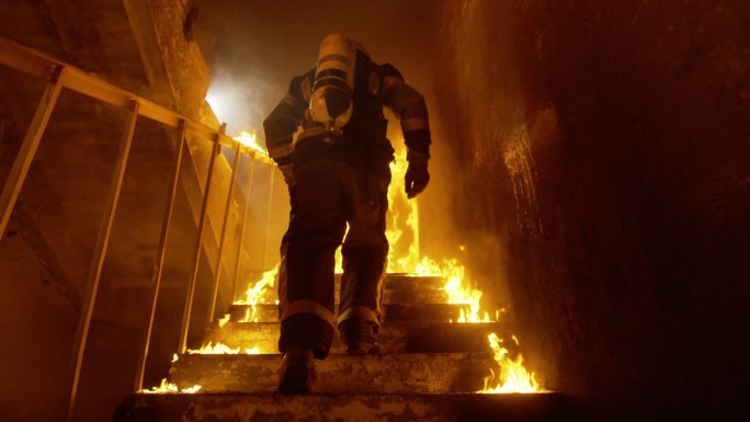 勇敢的消防队员跑上燃烧的楼梯