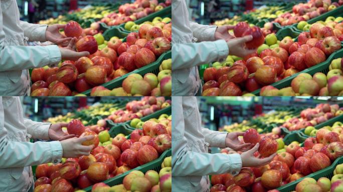 年轻的女人和小女孩在超市挑选苹果