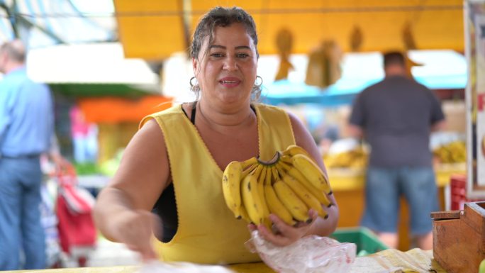 自信的商贩在农贸市场卖香蕉
