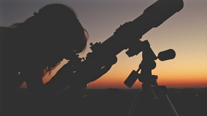 女孩用望远镜看星星