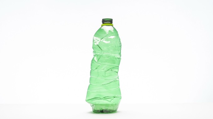 在白色背景上压碎塑料瓶，停止运动