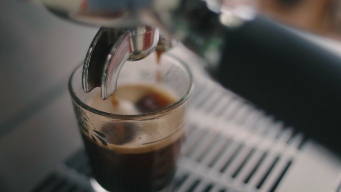咖啡从机器滴到杯子里。