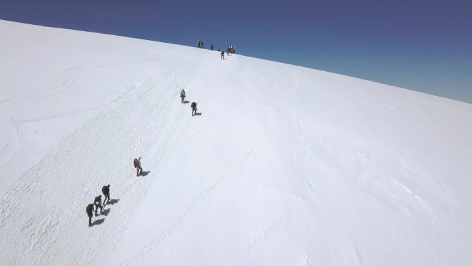 旅游团走在雪山小径上