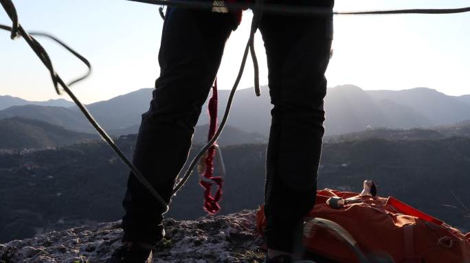 男登山者在山顶整理绳索