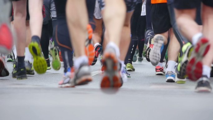 马拉松比赛中特写跑步者的腿。