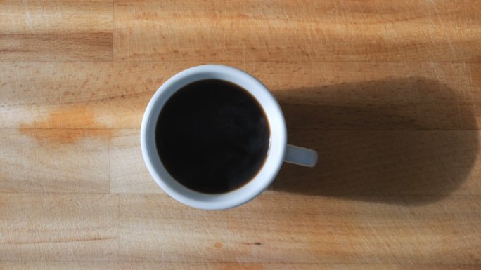 从木桌上拿一杯黑咖啡