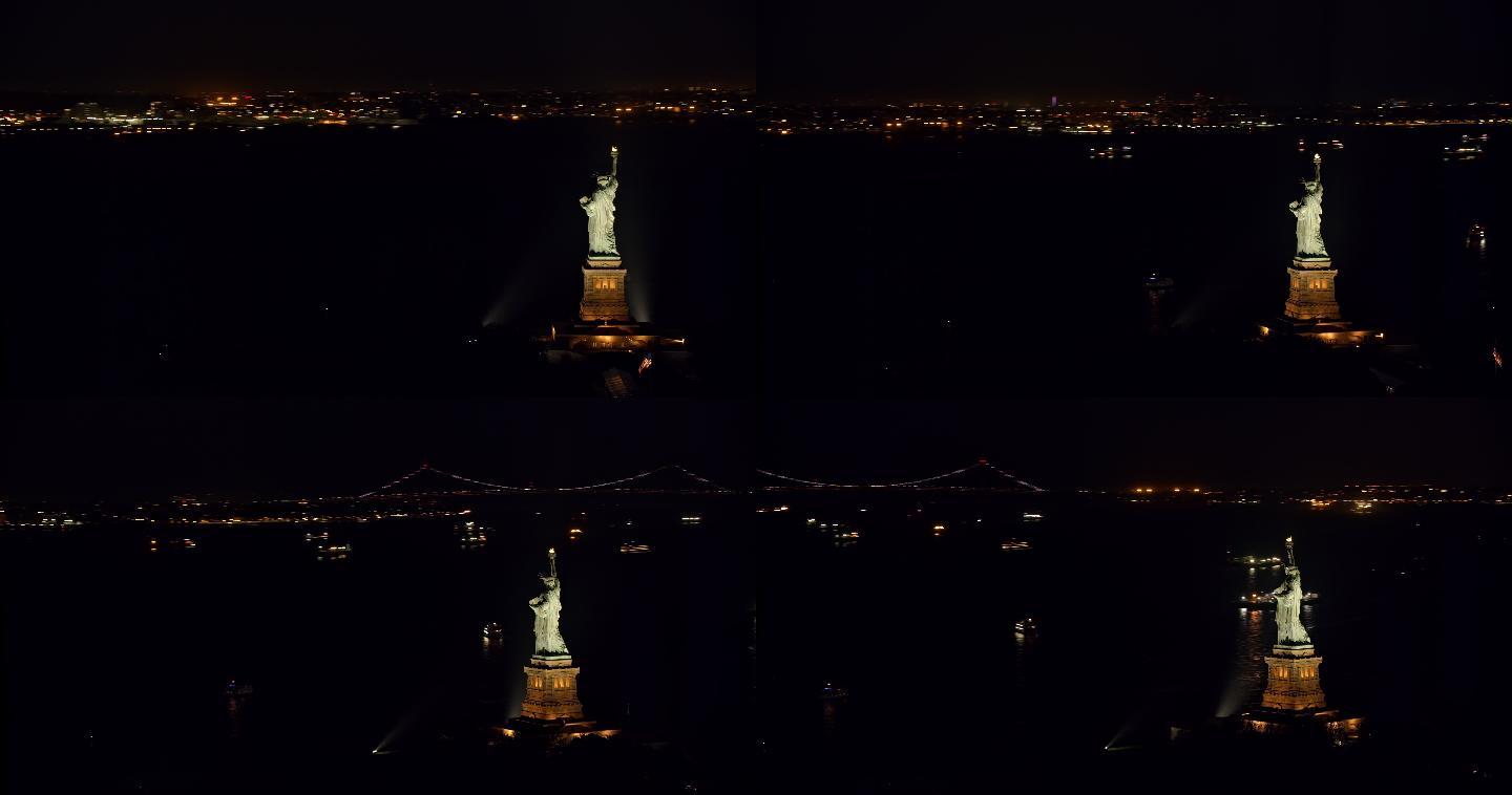 空中的自由女神像在夜晚闪耀在纽约港