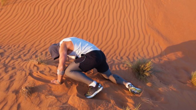 人在沙漠中跌倒后爬起来
